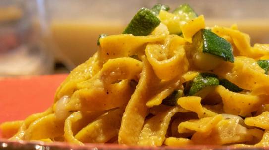 Tagliatelle con curcuma e pepe, fondente di cipolla, zucchine al curry e crema di alici